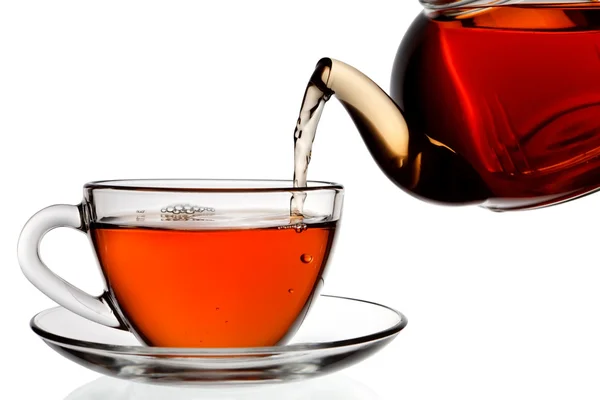 Tee wird in Glas Teetasse isoliert auf weißem Hintergrund gegossen — Stockfoto