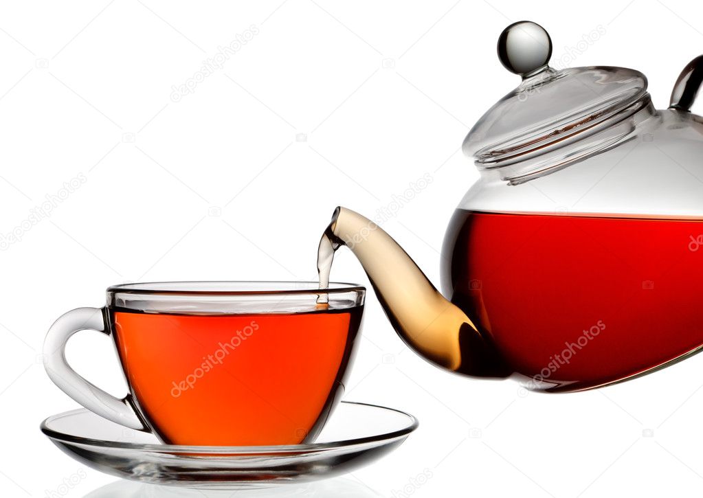 Tea being poured into glass tea cup isolated on a white backgrou