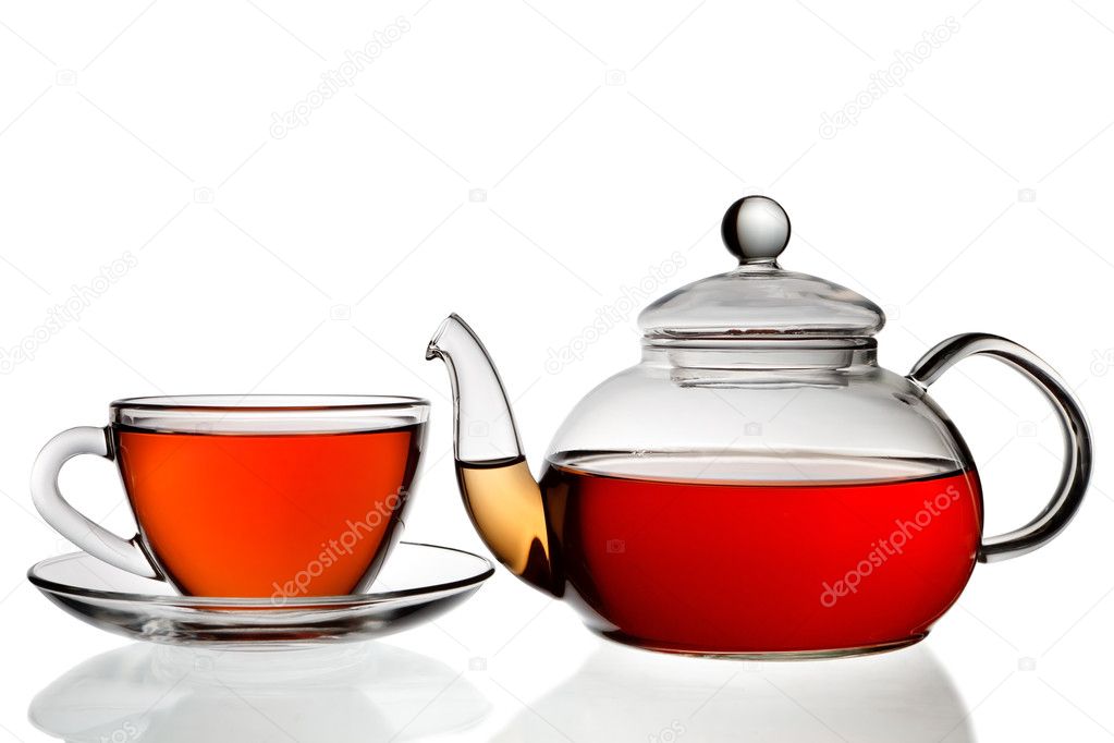 Tea being poured into glass tea cup isolated on a white backgrou