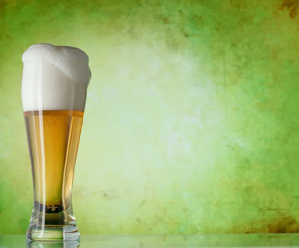 Glass of beer on a green background — Stock Photo, Image