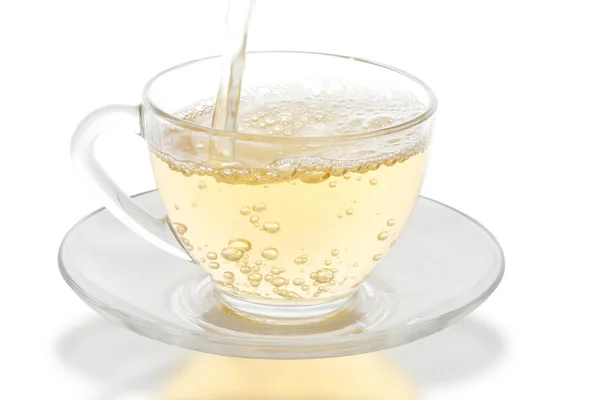 Té verde vertiendo en la taza de vidrio — Foto de Stock