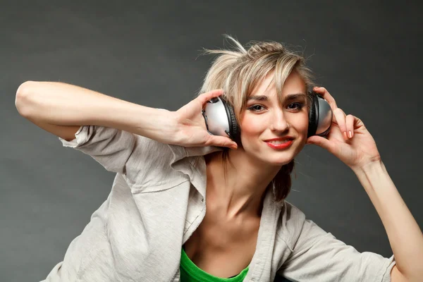 stock image Young girl listening to music by headphones