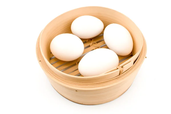 Four white eggs in bamboo basket — Stock Photo, Image
