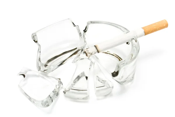 Smoking cigarette in broken glass ashtray — Stock Photo, Image