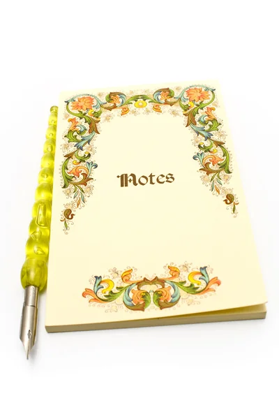 Cuaderno amarillo y pluma vieja —  Fotos de Stock