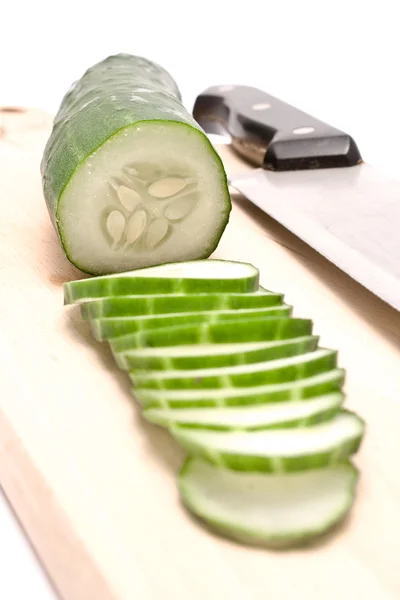 Cucumbers sliced on wooden board — Stock Photo, Image
