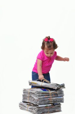 Toddler placing a stack of paper ready for recycling clipart