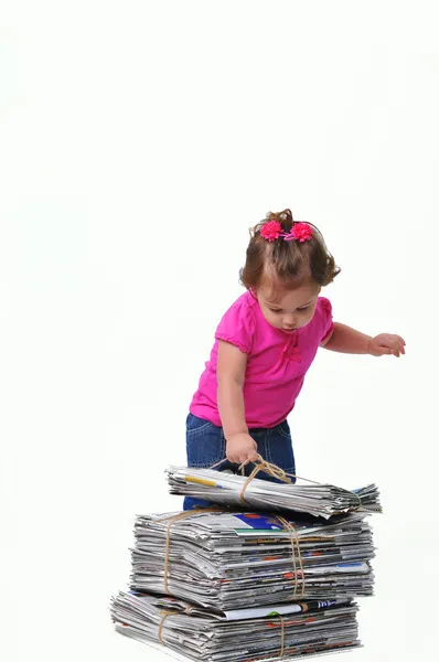 Toddler placing a stack of paper ready for recycling — Stock Photo, Image