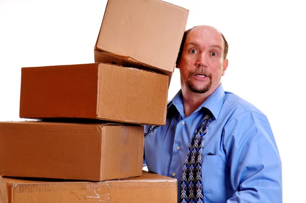 Man carrying heavy boxes with one about to fall. — Stock Photo, Image