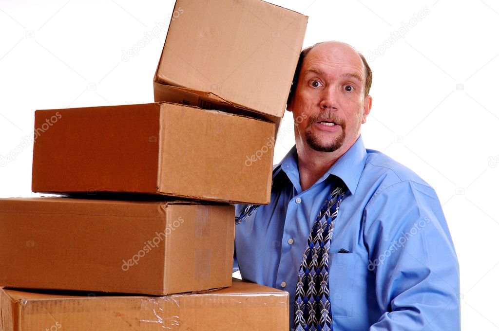 Man carrying heavy boxes with one about to fall.