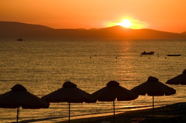 Beach with a glowing sun clipart