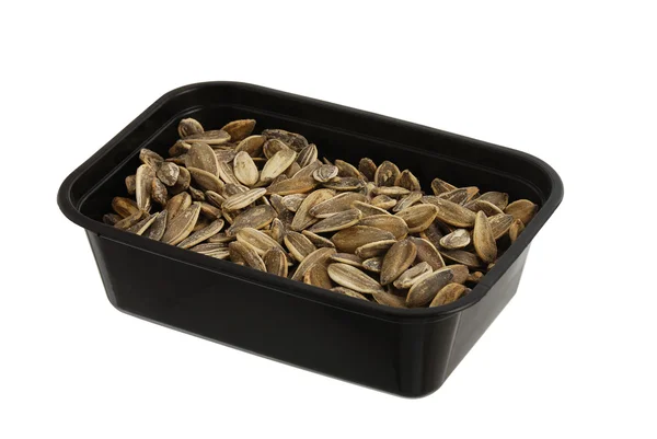 Dried and salted sunflower seeds in plastic bowl — Stock Photo, Image