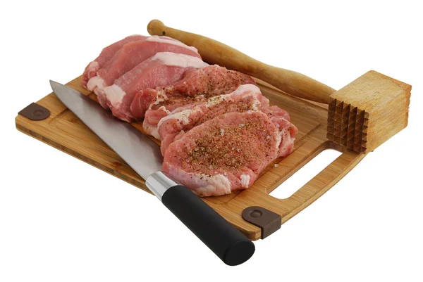 Chuletas sazonadas en tabla de cortar de bambú con cuchillo de chef y carne — Foto de Stock