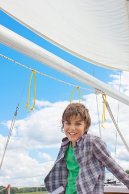 Boy sailng on yacht clipart