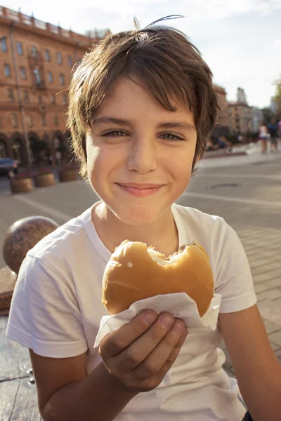Χαμογελαστό αγόρι με χάμπουργκερ — Φωτογραφία Αρχείου