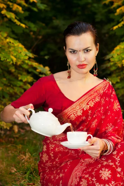 Mujer en sari indio con tetera y taza de té — Foto de Stock