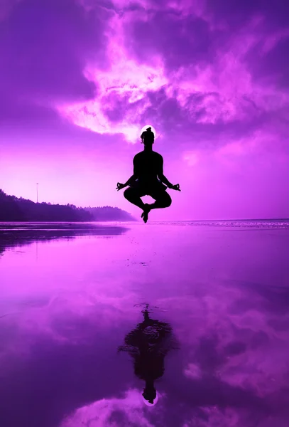 Yoga padmasana in jumping on the beach — Stock Photo, Image