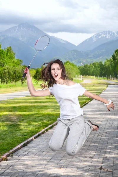 Mulher furiosa jogando badminton — Fotografia de Stock