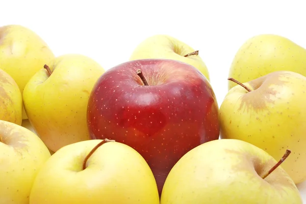 Red apple in the middle of yellow apples — Stock Photo, Image