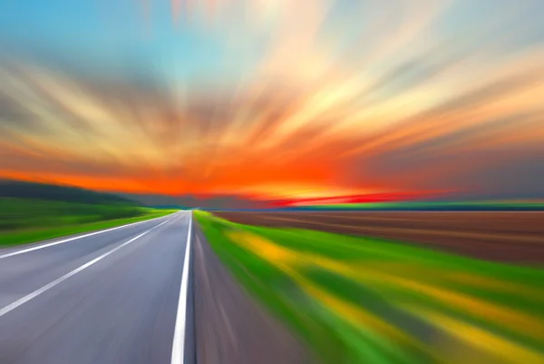 Carretera borrosa y cielo borroso con puesta de sol — Foto de Stock