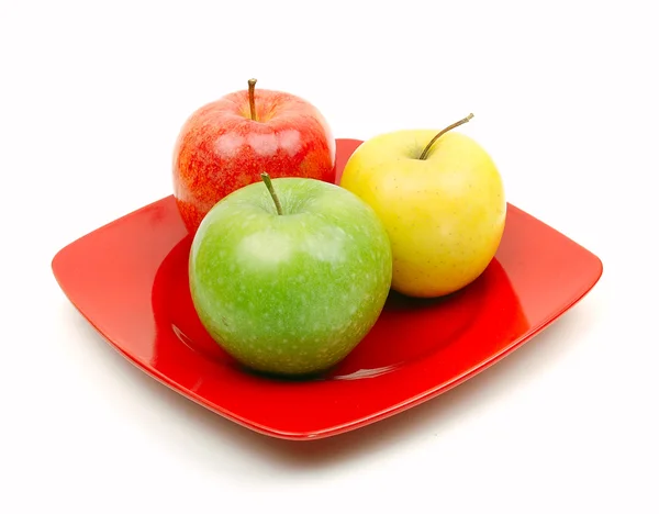 Äpplen på röda tallrik — Stockfoto