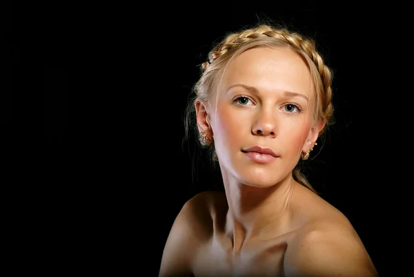 Porträtt av en blond tjej med en fläta på svart bakgrund — Stockfoto