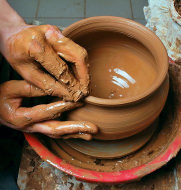 Hands of a potter, creating an earthen jar on the circle clipart