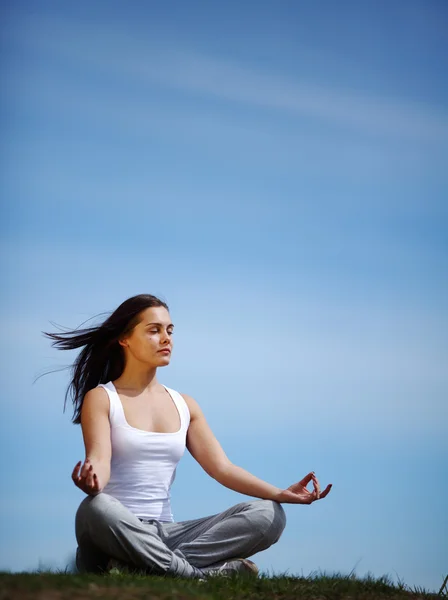Beautiful young girl training yoga on sunny meadow — Stock Photo, Image
