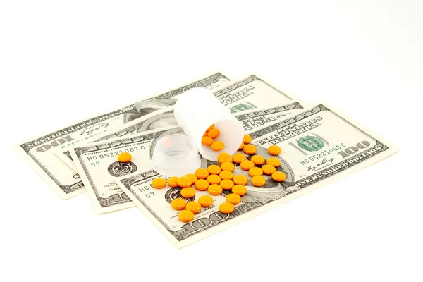 stock image Orange pill at the money , isolated on white background