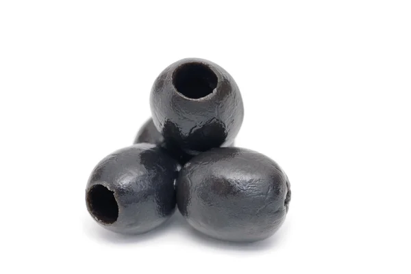 Drei schwarze entkernte Olivenfrüchte in Nahaufnahme auf weißem Hintergrund — Stockfoto