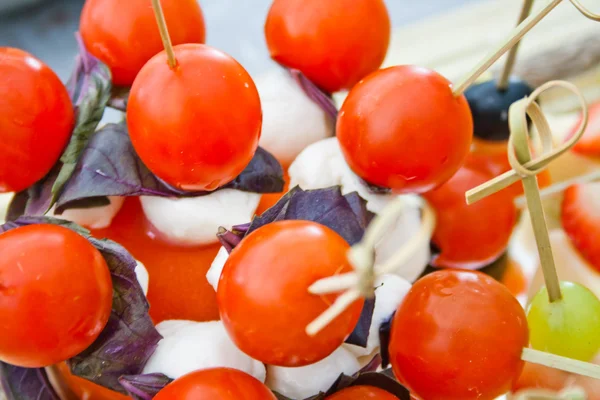Small tomatos with mozzarella on skewer — Stock Photo, Image