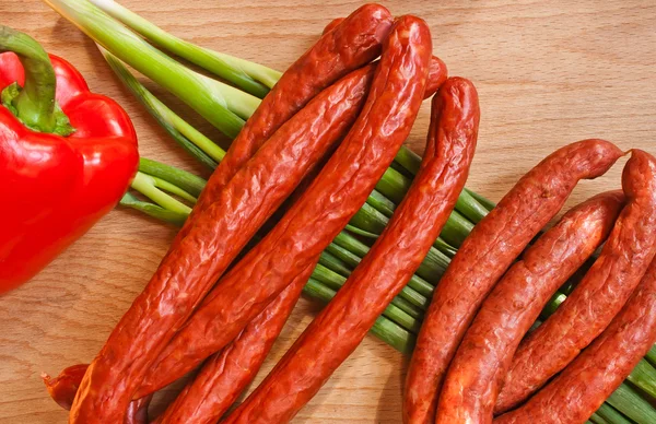 Any sausage on green onion — Stock Photo, Image