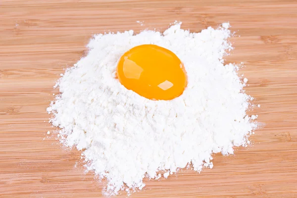La yema del huevo de las gallinas de casa y la harina de trigo en la tabla de la cocina — Foto de Stock