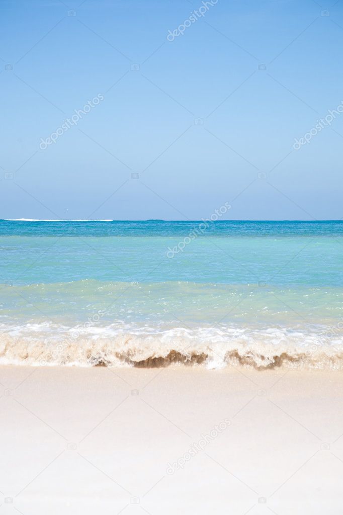 Summer beach background with clean sand and blue sky