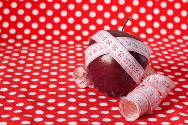Červené jablko a měřicí páska — Stock fotografie