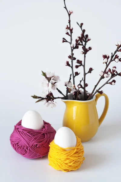 Huevos de Pascua decorativos y un montón de ramitas de flores de cerezo — Foto de Stock
