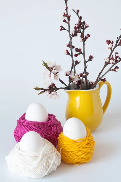 Dekorative Ostereier und ein Bund Kirschblütenzweige — Stockfoto