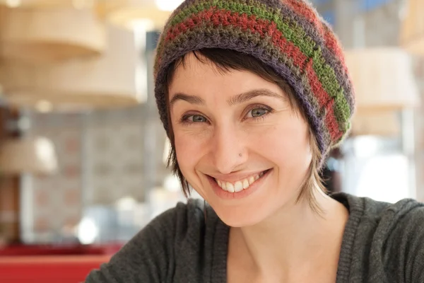 Portret van een mooie jonge brunette in een kleurrijke baret — Stockfoto