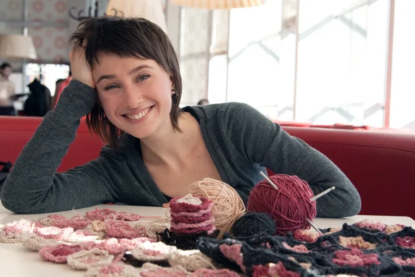 Portrett av en ung, vakker jente med strikking stockbilde