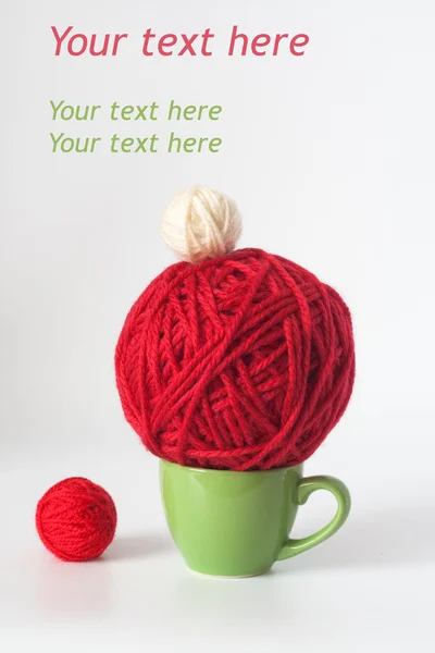 Pohár zelené a červené kuličky příze pro pletení — Stock fotografie