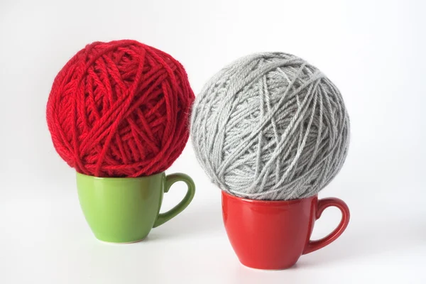 Poháry zelené a červené, šedé a zelené klubko příze pro pletení — Stock fotografie