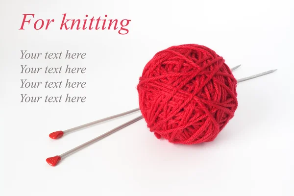 Uma grande bola vermelha de fios e duas agulhas longas para tricotar — Fotografia de Stock