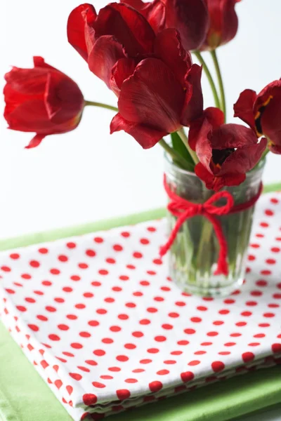 红色郁金香和圆点桌布的花束 — 图库照片