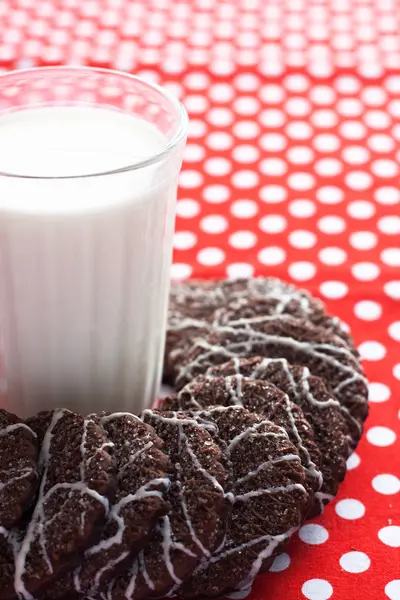 Ein Glas Milch und leckere Kekse auf einem weißen Teller — Stockfoto