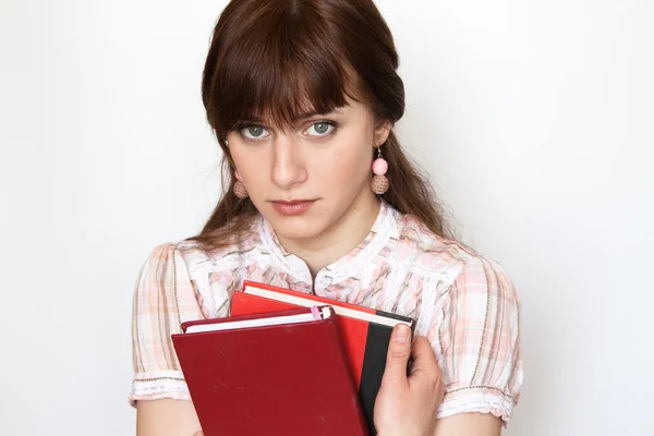 Una hermosa joven estudiante sosteniendo el libro de trabajo. Ella está molesta y triste. — Foto de Stock