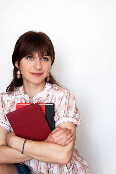 Eine schöne junge Studentin hält Bücher in der Hand und lächelt — Stockfoto