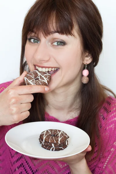 Młoda brunetka, jedzenie pyszne czekoladowe ciasteczka — Zdjęcie stockowe