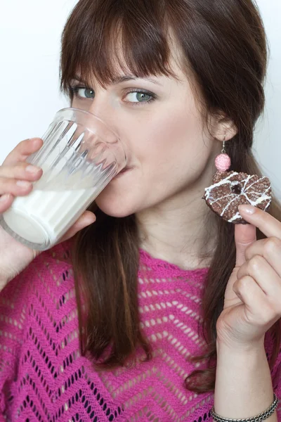 Young beautiful brunette eating delicious chocolate cookies — Stock Photo, Image