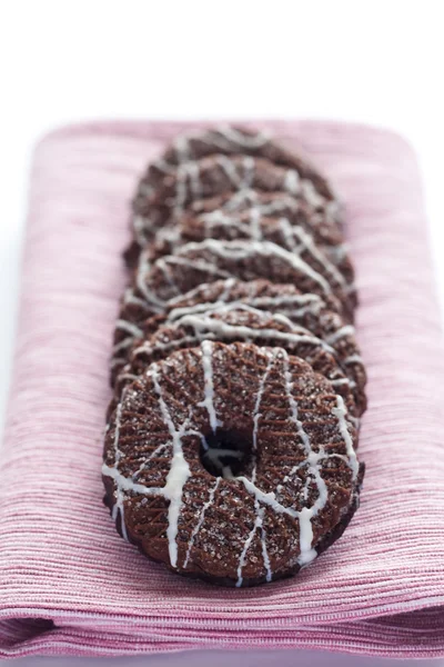 Deliciosos biscoitos de chocolate com cobertura em um guardanapo rosa — Fotografia de Stock