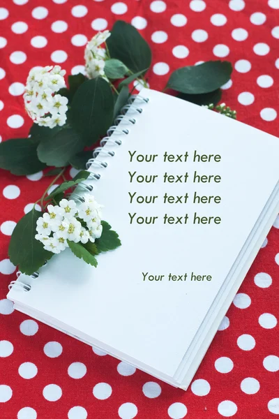 Caderno de notas e um ramo com flores brancas — Fotografia de Stock